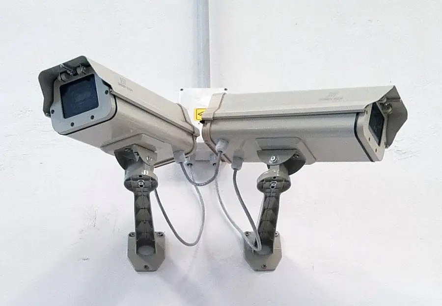 Dos cámaras exteriores montadas en pared, con su cableado prolijo hacia el techo.
