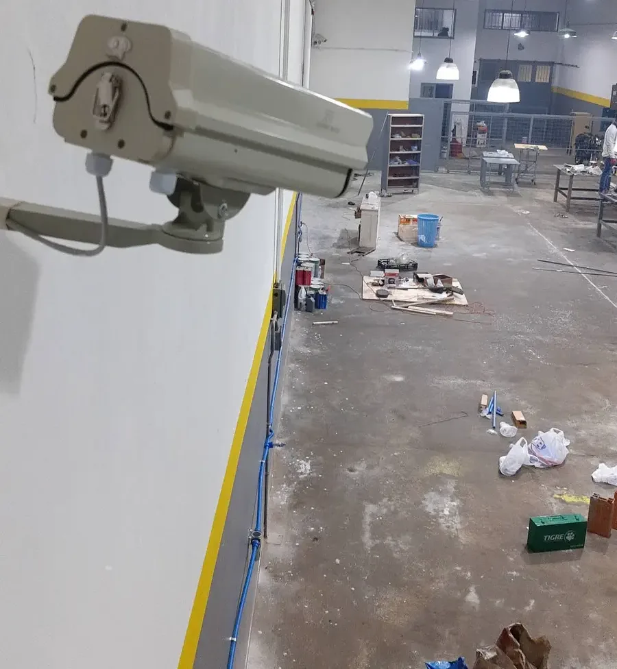 Cámara instalada en altura sobre un galpón industrial, con vista al piso de trabajo.