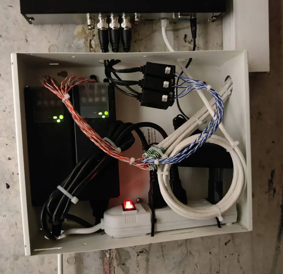 Caja de conexiones abierta con el cableado de cámaras ordenado y prensado.